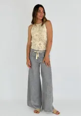 Pantalón gris de lino de corte palazzo con cintura alta y lazo ajustable.