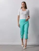 Pantalón capri blanco de gabardina elastizada. Pretina ancha elastizada, delantera con bolsillos simulados y trasera con bolsillos aplicados.