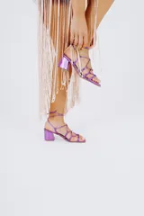 Sandalias de tacón cuadrado color fucsia metalizado, con tiras finas que se atan alrededor del tobillo.