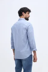 Camisa de manga larga fit semi slim color celeste, con cierre frontal de botones y cuello camisero clásico.