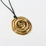 Collar con dije dorado en forma de espiral irregular, colgando de un cordón negro.