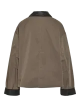 Campera de estilo worker color marrón topo, con cuello camisero y puños en contraste de color negro. Presenta cierre frontal con botones a presión metálicos, dos bolsillos frontales con solapa y diseño de corte holgado.