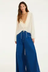 Pantalón de jean azul de calce amplio, con pata tipo elefante que se abre desde la cadera y aporta movimiento.