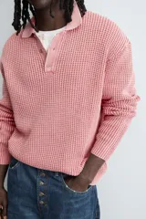 Polo de manga larga con tejido de punto de algodón con estructura tipo waffle. Presenta cuello solapa y cierre frontal con botonadura, con un acabado de efecto lavado.