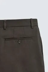 Pantalón de corte recto confeccionado en tejido compacto de algodón con estructura twill. Presenta cierre frontal con cremallera y botón, bolsillos laterales y bolsillos traseros de vivo con botón.