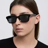 Lentes de sol con montura cuadrada de diseño angular y acabado brillante. Cuentan con lentes polarizadas de color negro y protección UV400.