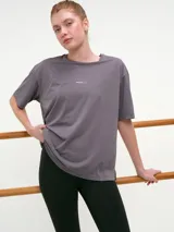 Remera deportiva blanca de manga corta, cuello redondo y corte oversized con tecnología dry fit.