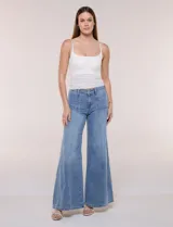 Pantalón jean de tiro alto con calce ajustado en la cadera y pierna de corte ancho tipo wide leg. Presenta costuras verticales en el frente y bolsillos aplicados.