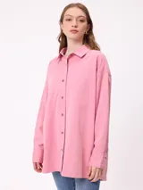 Camisa de manga larga con efecto lavado, corte oversize y cierre frontal con botones. Presenta cuello clásico y logo bordado en el pecho.