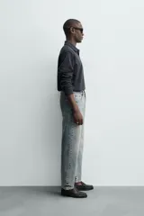 Jeans de corte recto y tiro medio confeccionados en denim de algodón con efecto lavado, diseño de cinco bolsillos y cierre frontal con cremallera y botón.