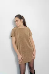 Vestido corto tipo remerón de lycra con acabado brillante color dorado. Presenta cuello redondo, mangas cortas y detalle de hombreras decoradas con tachas y cadenas metálicas.