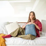 Mochila de cuero sintético color azul con diseño acolchado de rombos en el frente. Cuenta con bolsillo frontal con broche magnético, asa de mano superior y correas regulables. El compartimento principal incluye bolsillos internos con cierre y divisiones.