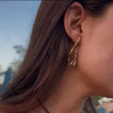 Aros colgantes con diseño orgánico inspirado en corales naturales, con acabado metálico brillante y cierre de perno con mariposa.