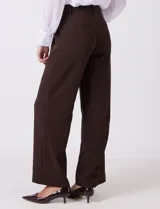 Pantalon wide leg de gabardina elastizada, con pretina con pasadores, cierre frontal con botón y broche, y bolsillos simulados tanto en la parte delantera como en la trasera.