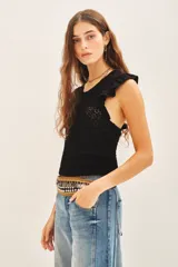 Musculosa de punto calado color crudo, con volados en las sisas y cuello redondo.