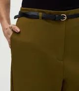 Pantalón carrot sastrero de corte recto y cintura alta, confeccionado en crepé. Presenta trabillas en la cintura, cierre tradicional y bolsillos traseros decorativos. Incluye un cinturón fino de material sintético.