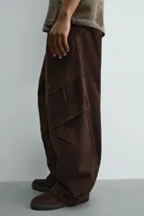 Pantalón cargo de corte relajado confeccionado en tejido de algodón con efecto lavado. Presenta cintura con pliegues frontales, bolsillos laterales con solapa en las perneras, bolsillos frontales y bolsillos traseros con solapa. Cierre frontal con cremallera y botón.