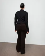 Pantalón de jean marrón oscuro, de tiro medio con diseño de corte recto y acabado ligeramente acampanado.
