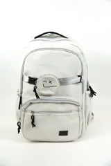 Mochila de poliéster color blanco con múltiples compartimentos con cierre, tiras ajustables y un pequeño monedero frontal con una carita feliz bordada.