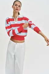 Sweater de punto con diseño de rayas horizontales en rojo y celeste, cuello polo blanco con escote en V y manga larga.