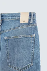Bermuda de jean con corte regular fit, confeccionada en denim de algodón con elasticidad. Presenta diseño de cinco bolsillos, efecto lavado y cierre frontal con cremallera y botón.