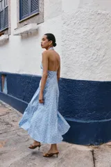 Vestido midi de algodón con estampado de lunares blancos sobre fondo celeste. Presenta cuello halter con cierre de botones y espalda descubierta, con un corte evasé fluido.