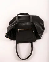 Bolso tote de cuero color tostado, con doble asa de hombro y diseño minimalista. Incluye un bolsillo separador extraíble.