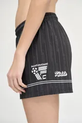 Short deportivo negro con rayas verticales blancas y cintura elástica.