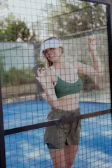 Top deportivo verde con breteles finos y contorno blanco.