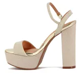 Sandalia de plataforma alta y taco grueso, color dorado brillante con textura glitter. Presenta una tira ancha en la parte delantera y una tira fina ajustable alrededor del tobillo.