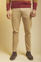 Pantalón de gabardina color beige, de corte recto y ajuste clásico, con cierre frontal y bolsillos laterales.