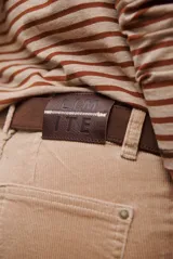 Pantalon de corte recto confeccionado en pana, con cintura media y cierre frontal.