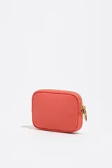 Monedero coral de Bimba y Lola con cierre de cremallera metálica dorada, detalle de logotipo metálico en el frente y bolsillo interior.