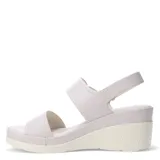 Sandalias de plataforma con diseño de tiras en cuero sintético color tostado. La tira delantera presenta una textura grabada, mientras que la tira trasera incluye un cierre con hebilla y detalle metálico. Posee una base de plataforma blanca con diseño estriado.