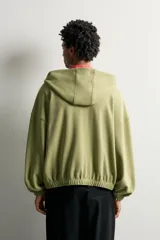 Cazadora relaxed fit de hombre, confeccionada en tejido estructurado tipo waffle con efecto lavado en color verde. Cuenta con cuello con capucha, cierre frontal con cremallera, bolsillos frontales tipo canguro y acabados elásticos en puños y bajo.