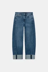 Jeans baggy de tiro medio con pernera holgada y bajo con vuelta. Cuenta con cinco bolsillos, cintura elástica en la parte trasera y cierre frontal con cremallera y botón metálico.