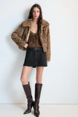 Cazadora de Zara con efecto pelo, diseño de cuello solapa y manga larga. Presenta un estampado animal print tipo cervatillo, bolsillos delanteros y cierre frontal con ganchos metálicos.