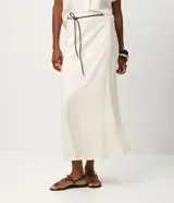 Pollera midi evasê color blanco, confeccionada en viscolino, con cintura alta y cinturón fino negro desmontable.