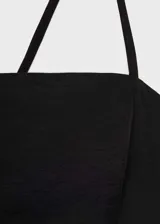 Vestido corto negro de corte evasé, con escote cuadrado, tirantes finos cruzados en la espalda y detalle de pinzas en el frente.