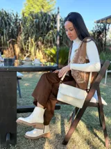 Bota corta de cuero vacuno con textura granulada, color crudo. Presenta cierre lateral metálico, tirador en la parte trasera y suela track de goma en tono contrastante.