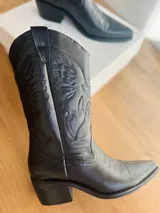 Botas texanas negras de cuero con bordados decorativos y taco bajo.