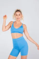 Top deportivo celeste con tiras regulables y desmontables para usarlo de tres formas distintas: con una tira cruzada detrás del cuello, con tiras rectas o tiras cruzadas por detrás.