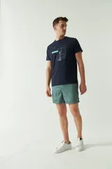 Short de baño estampado con diseño geométrico en tonos verdes, cintura elástica con cordón ajustable, bolsillos laterales y bolsillo trasero.