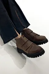 Botas marrones de cuero con suela track negra y ajuste con dos tiras de velcro.