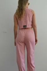 Chaleco corto a rayas verticales rojas y blancas, con cuello redondo y sisas amplias.