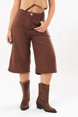 Bermuda de silueta amplia y tiro medio, color marrón chocolate, con bolsillos delanteros y traseros, cierre frontal con cremallera y botón.