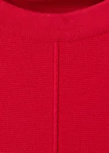 Chaleco rojo de punto fino, de diseño recto, cuello redondo y manga corta.