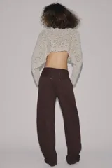 Pantalón cargo de tiro medio confeccionado en algodón, con diseño de pierna tipo barril. Presenta bolsillos laterales y bolsillos de plastrón con solapa en las piernas, además de un bajo ajustable con trabillas y hebilla metálica.