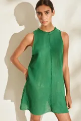 Vestido corto de lino italiano color verde, sin mangas, con cuello redondo a la base y detalles desflecados en el cuello y costuras.