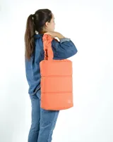 Bolso tipo totebag acolchado color amarillo, con manijas cortas y logo bordado en una esquina. Ideal para transportar una laptop.